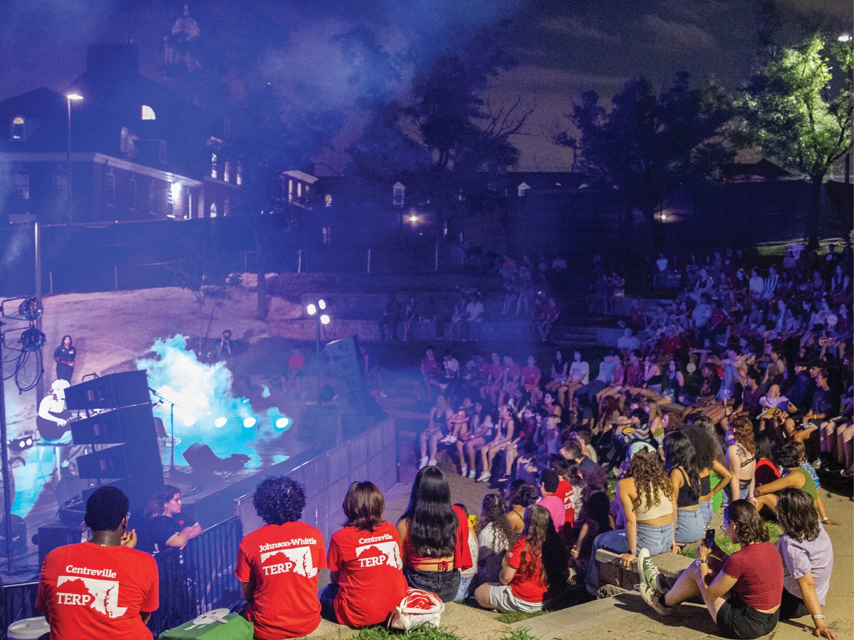 A large group of UMD students take in a nighttime concert at the Nyumburu Ampphitheater