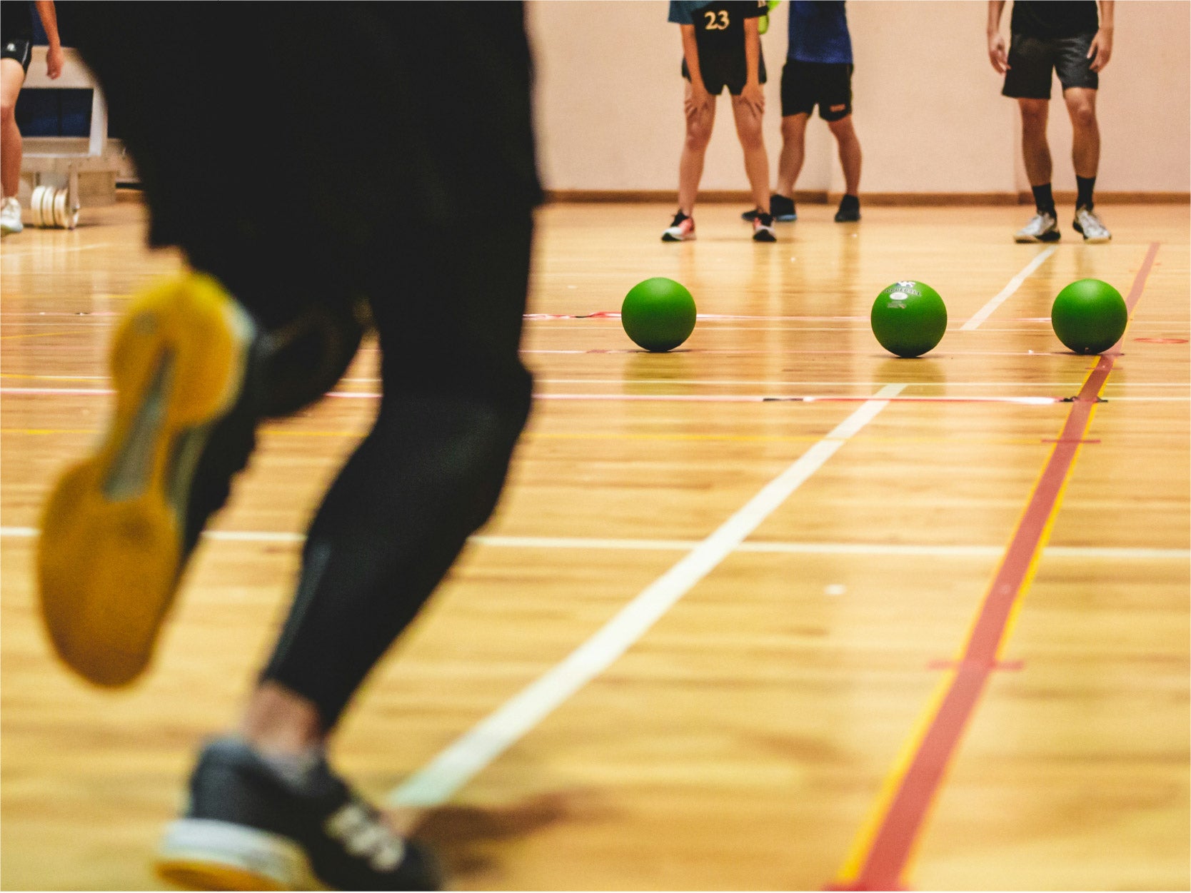 A photo of a dodgeball game. Showcasing only the bottom half of participants.