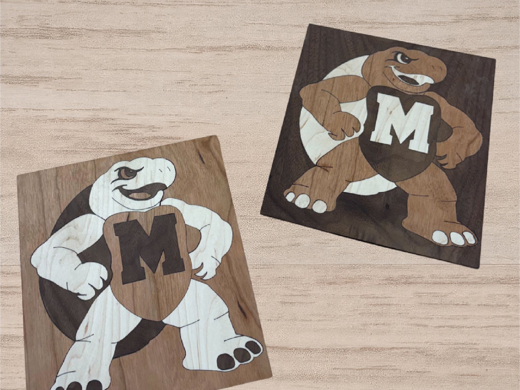 An Image of 2 testudo Marquetry projects made in the keystone woodshop.