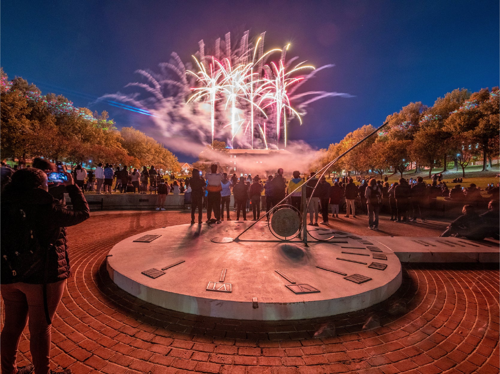 A photo of students gathered at Mekeldin Mall viewing a firework show.