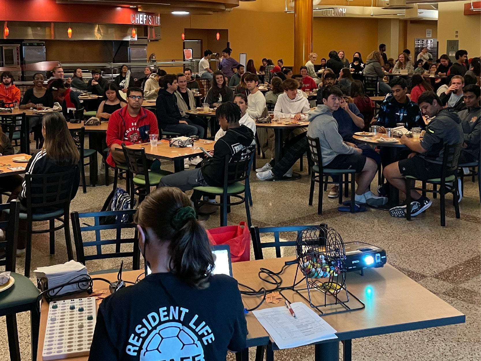 A photo of a group of students playing BINGO in a dining hall.
